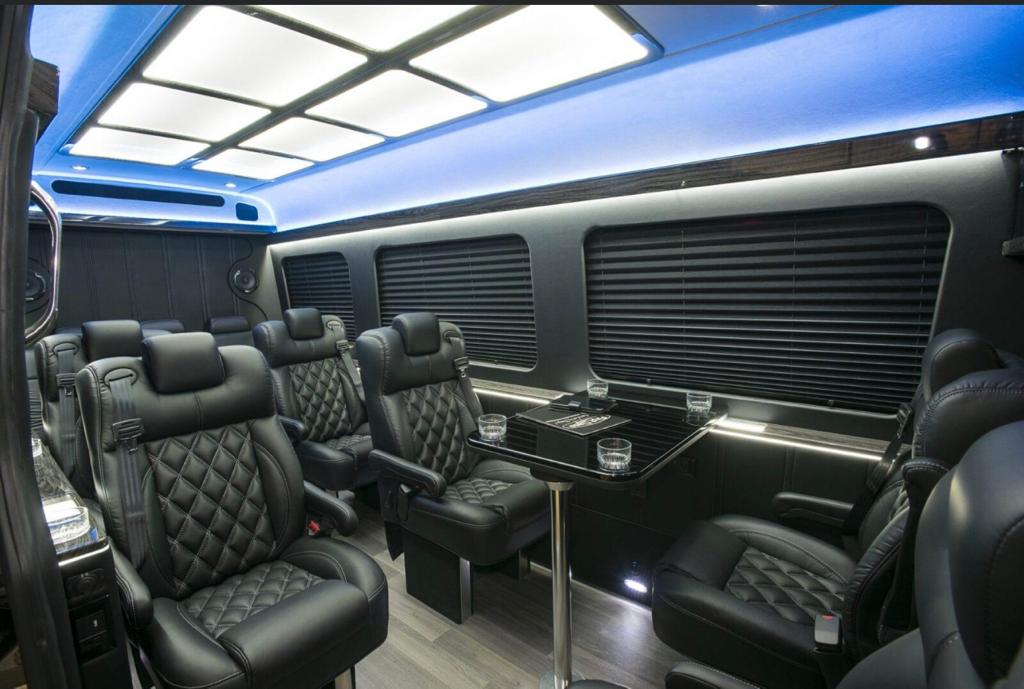 Castle Rock Limo Services 2 Close-up of Mercedes sprinter interior with black leather seats and a black dining table.
