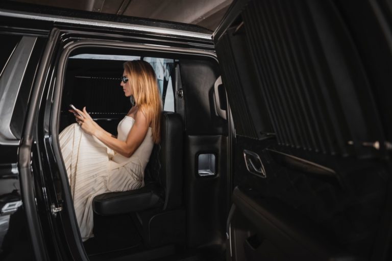 Castle Rock Limo Services 4 Long-haired woman inside a limousine using a mobile phone.